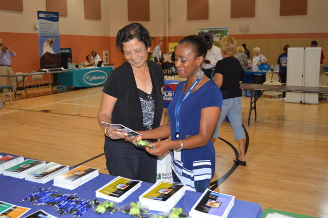 Couple looking over booklets at the senior expo
