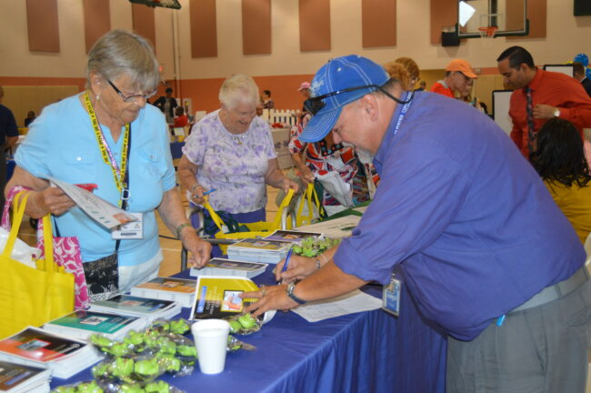 Giving out booklets at the senior expo